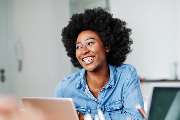 Woman with computer smiling, AdobeStock_318597182