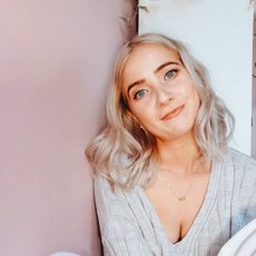 Image shows Aoife P Rafter sitting on the floor and looking at the camera