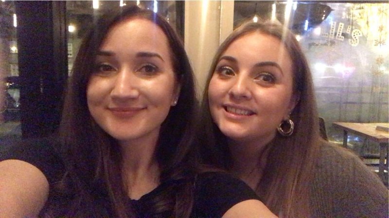 Photo of two young white women standing closely together