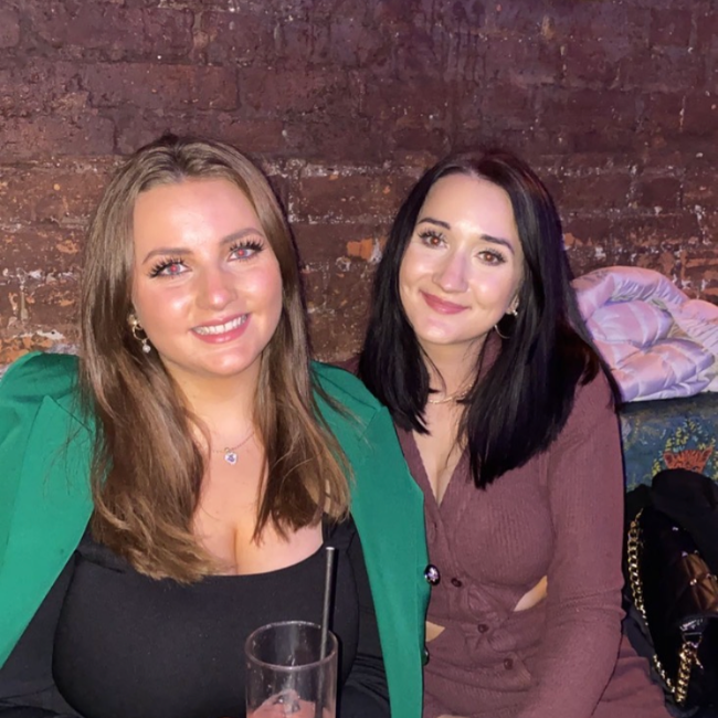 Photo of two young white women sitting closely together