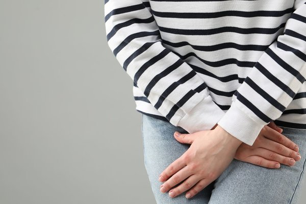 A woman clutches at her legs as if needing the toilet