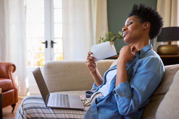 A woman fanning herself with a piece of paper