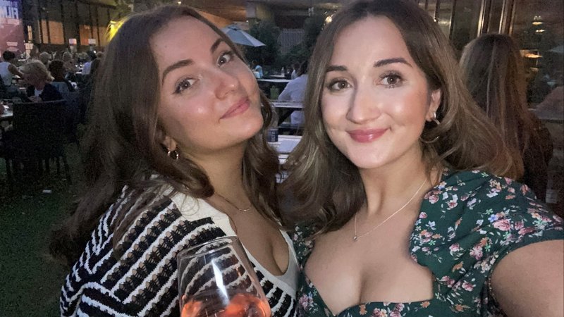 Photo of two young white women standing closely together