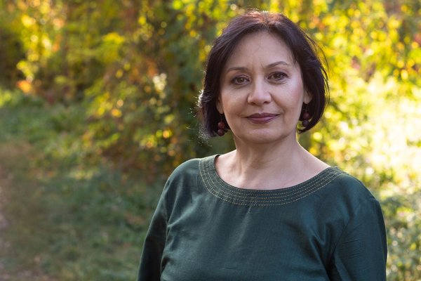 An older woman stands in the garden