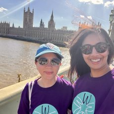 Image of walkers from PwC walking over a bridge with the Houses of Parliament behind them.