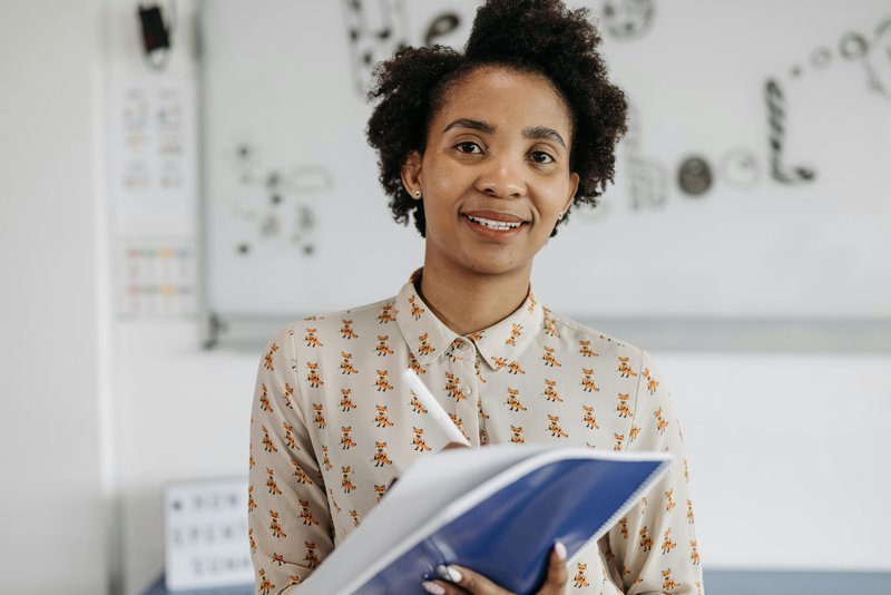 Photo of smiling black woman with a pen