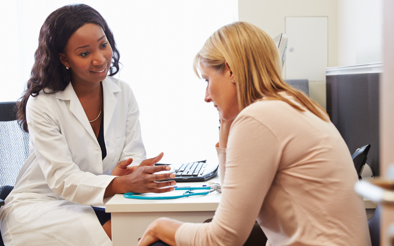 A worried woman speaks to a female doctor