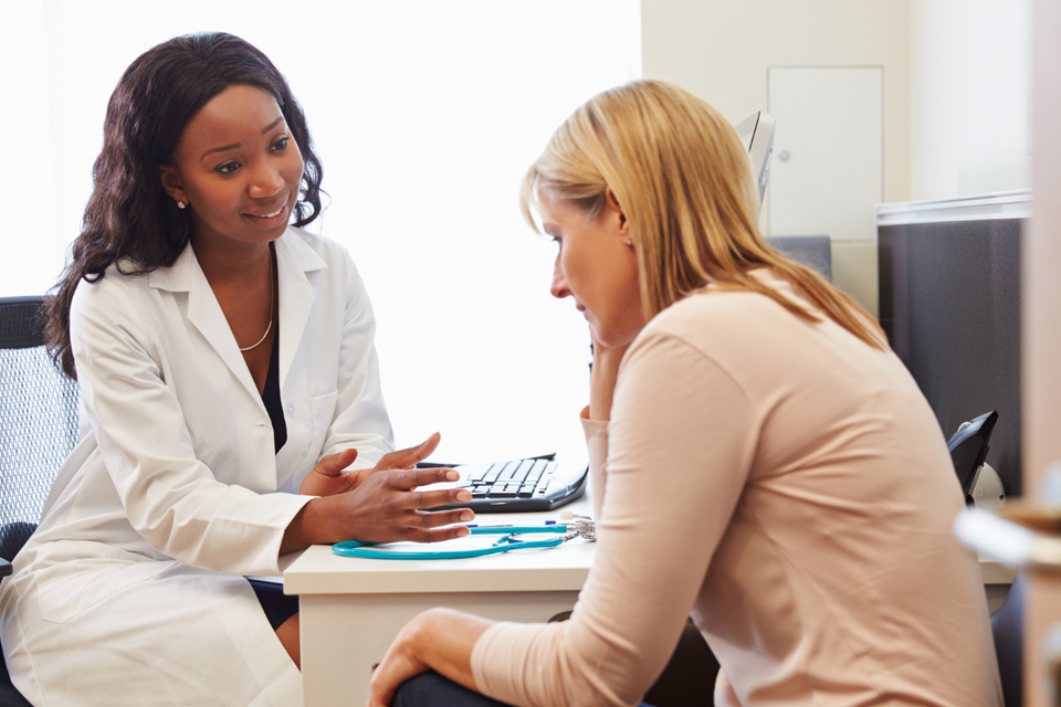 A worried woman speaks to a female doctor